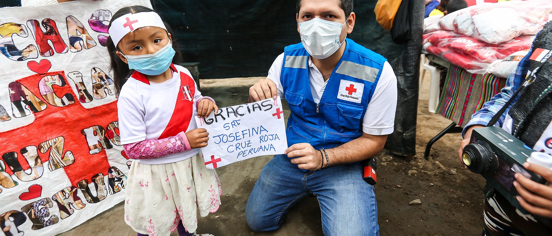 Mädchen und Rotkreuz-Helfer während der Corona-Pandemie in Peru
