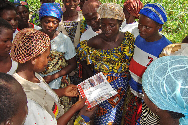 Frauengruppe in betrachtet ein Merkblatt zur Katastrophenvorsorge im Togo