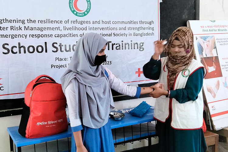 Zwei Schülerinnen zeigen Erste-Hilfe-Maßnahmen