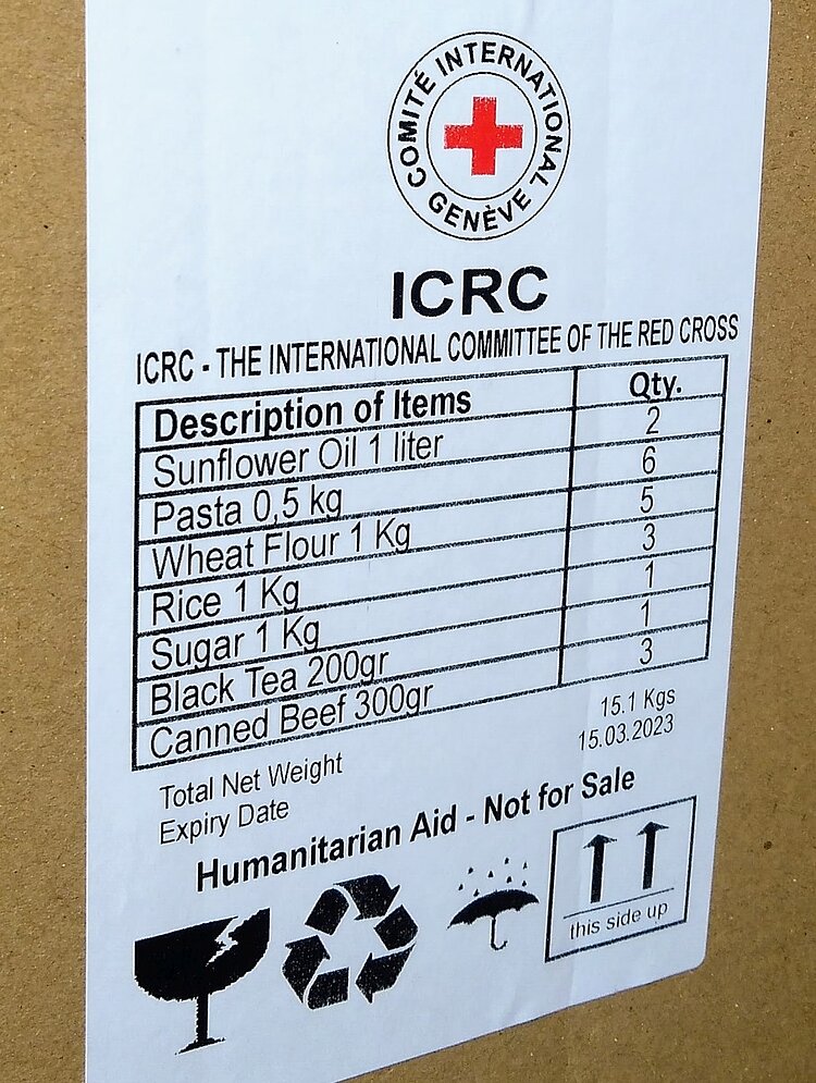 Ein Hilfspaket mit dem Logo des IKRK mit aufgedrucktem Etikett und Inhaltsangaben zu verschiedenen Lebensmitteln