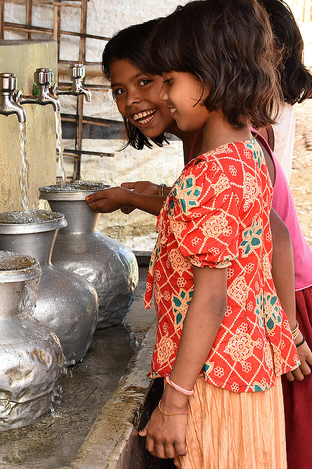 Bangladeschische Mädchen an Wasserhähnen
