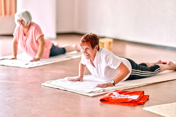 Yoga beim DRK Zwei Frauen liegen auf Bodenmatten