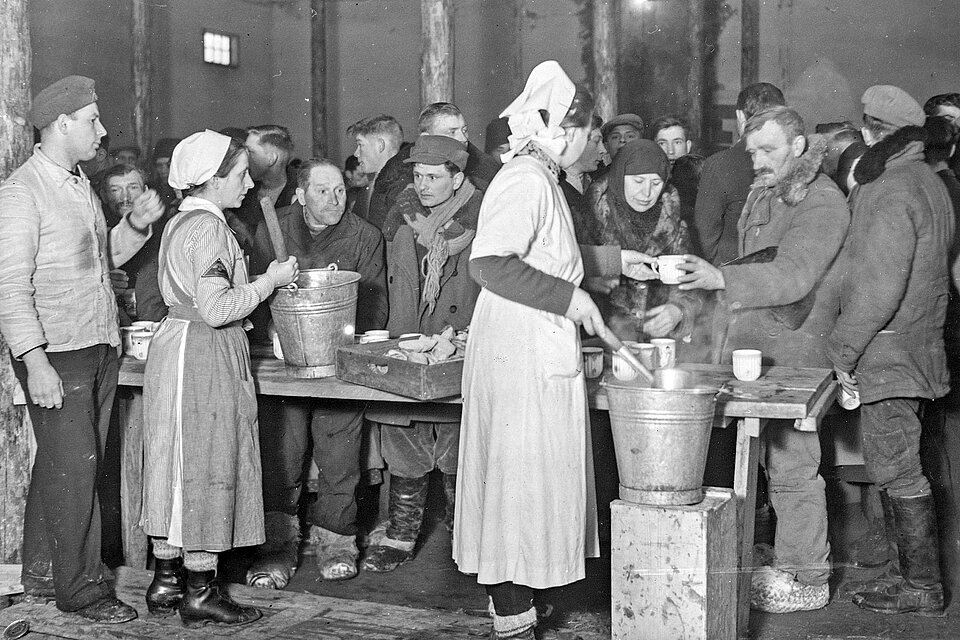 DRK-Helferinnen verteilen Getränke an Menschen