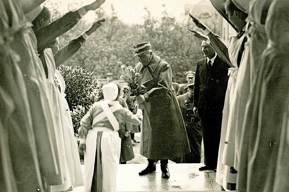 Schwesternhelferin übergibt Mann Blumen