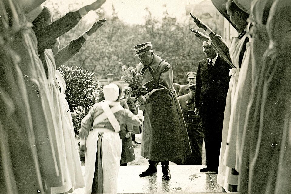 Schwesternhelferin übergibt Mann Blumen