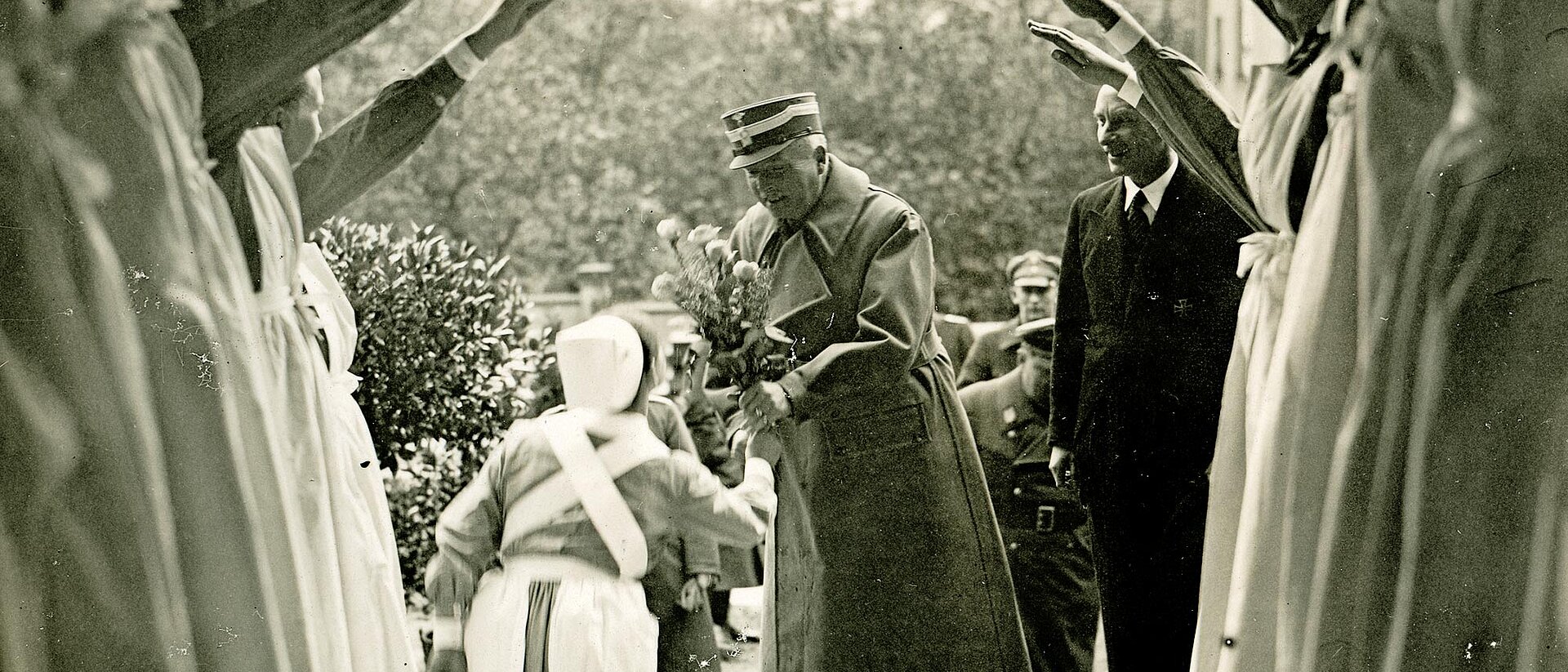 Schwesternhelferin übergibt Mann Blumen