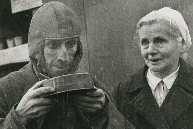 Kriegsheimkehrer aus der Sowjetunion erhält im Lager Friedland von einer DRK-Helferin Verpflegung (DRK)