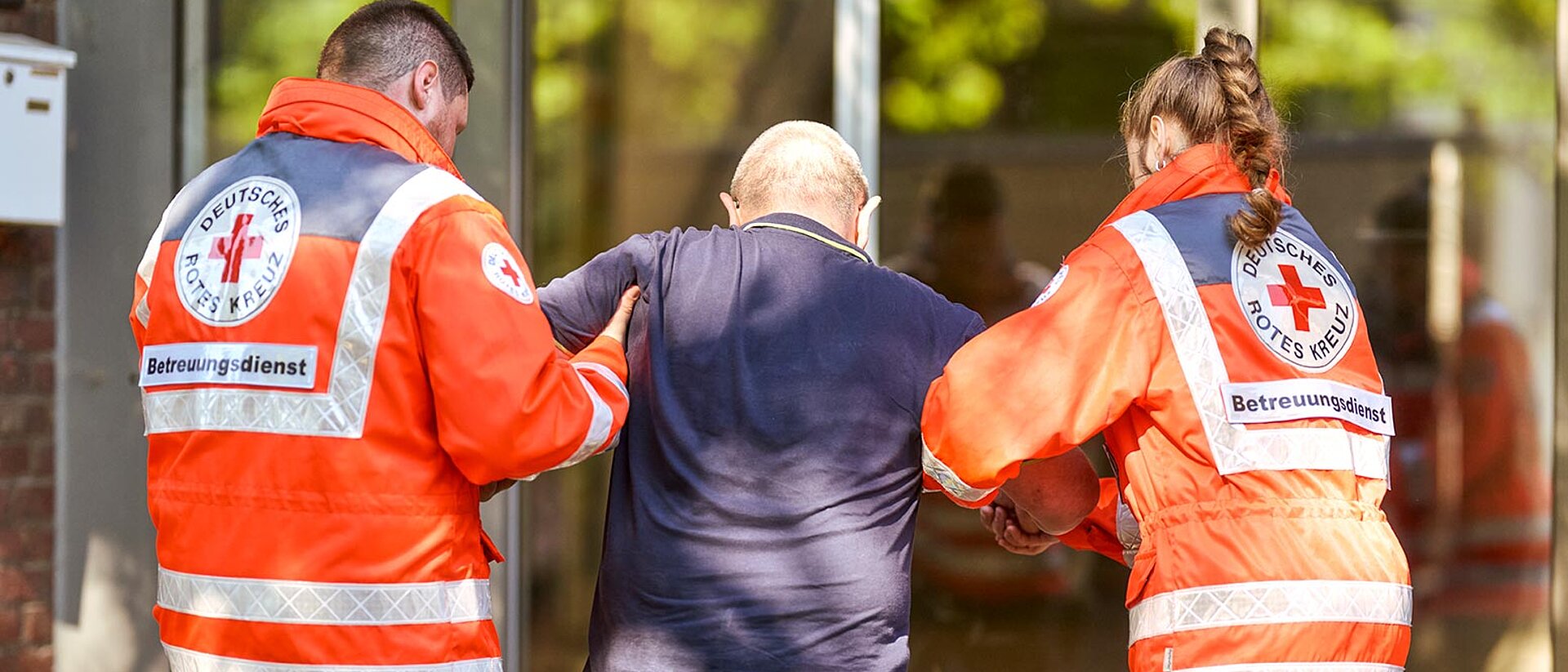 Betreuungsdienst Helfer stützen älteren Mann