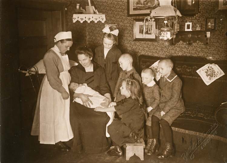 Schwester vom Vaterländischen Frauenverein Lüneburg und eine Mutter mit ihren sechs Kindern (DRK)