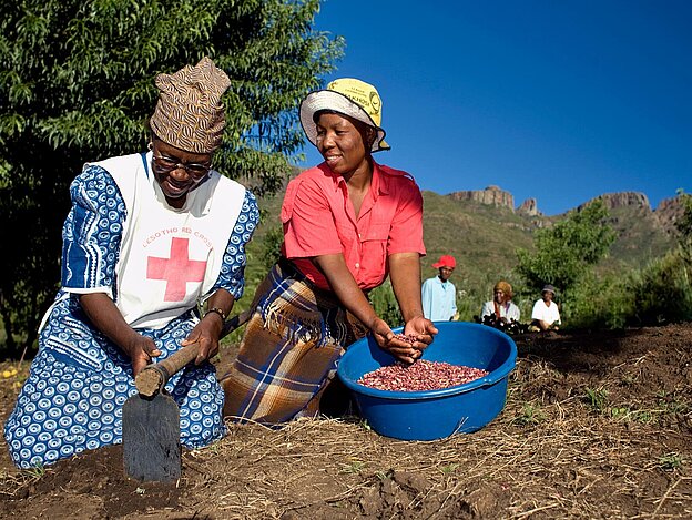 Two women spreading seeds 