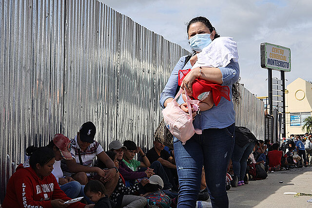 Füchtlinge in Honduras  in Armut: Mutter mit Kind vor sitzenden Migrierenden