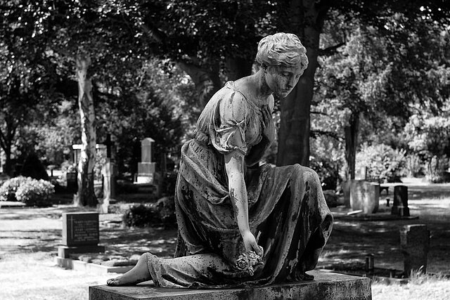 Statue einer trauernden Frau auf Friedhof