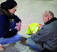 Sozialarbeiterin kümmert sich um einen Mann ohne Obdach