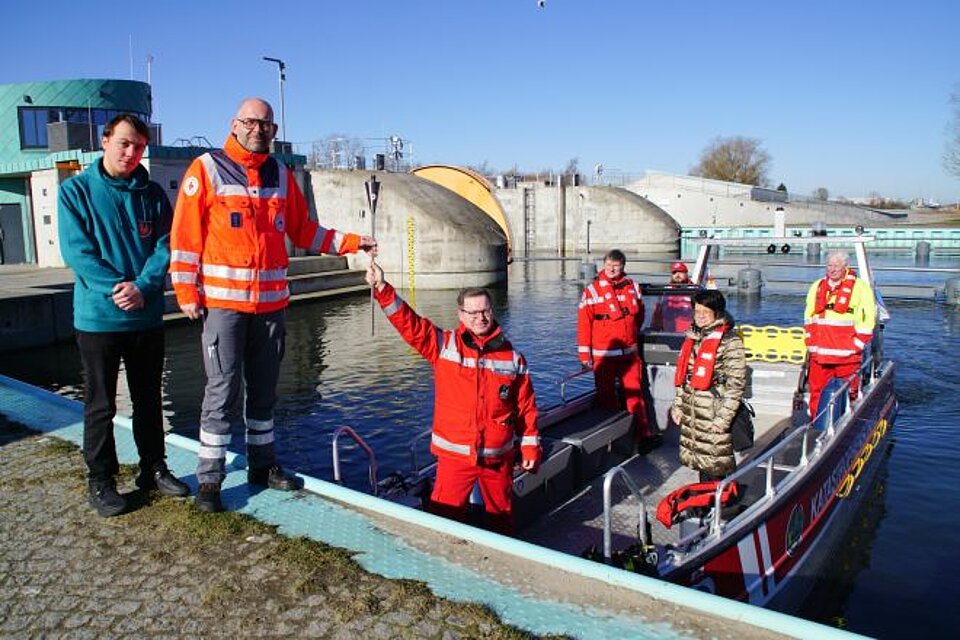 Die Übergabe der Fackel am Sperrwerk Greifswald-Wieck vom OV Greifswald an das Team des KV Rügen-Stralsund