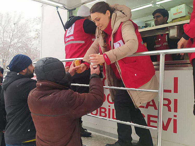 Helferin verteilt Mahlzeiten nach Erdbeben in der Türkei