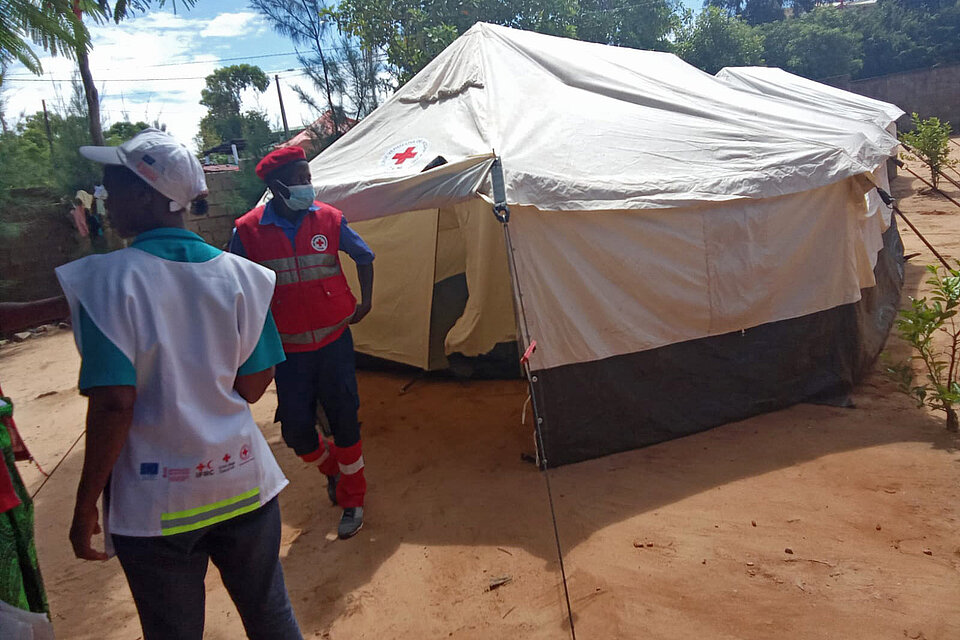 Helfende vor aufgebautem Zelt