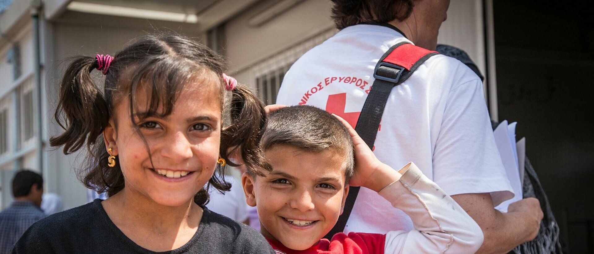 Two children with Red Cross employees