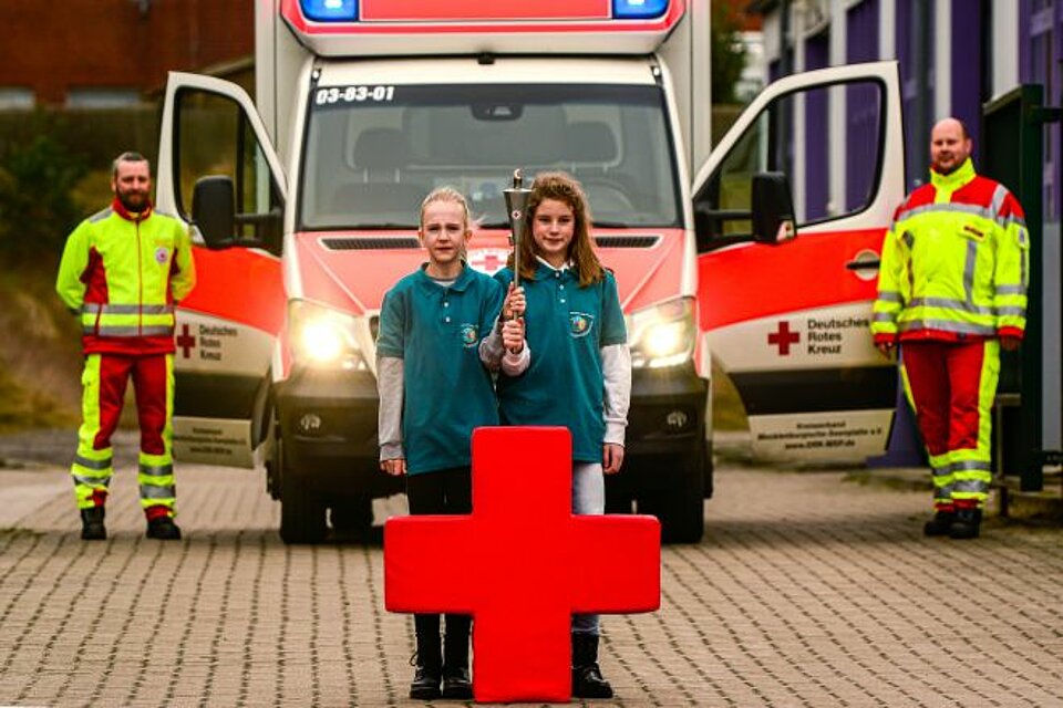 Die engagierten Jugendrotkreuzlerinnen Lina und Amy Stella mit der Fackel.