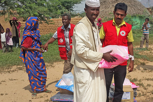 Mann erhält Hilfsgüter von DRK-Mitarbeiter im Sudan 