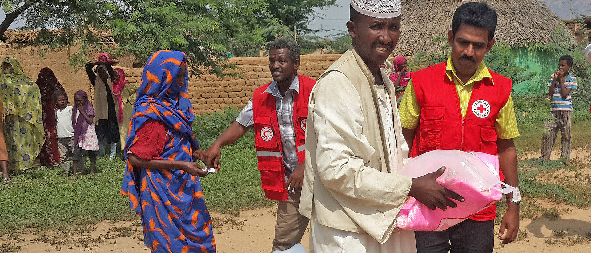 Mann erhält Hilfsgüter von DRK-Mitarbeiter im Sudan 