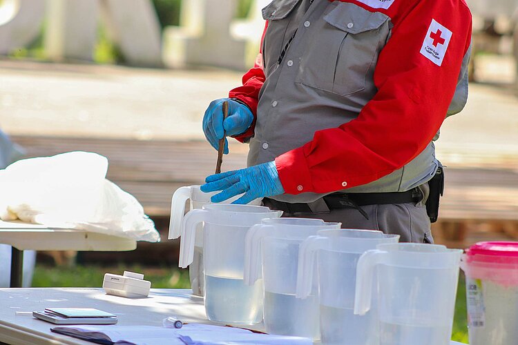 Rotkreuzler nimmt Proben aus Bechern