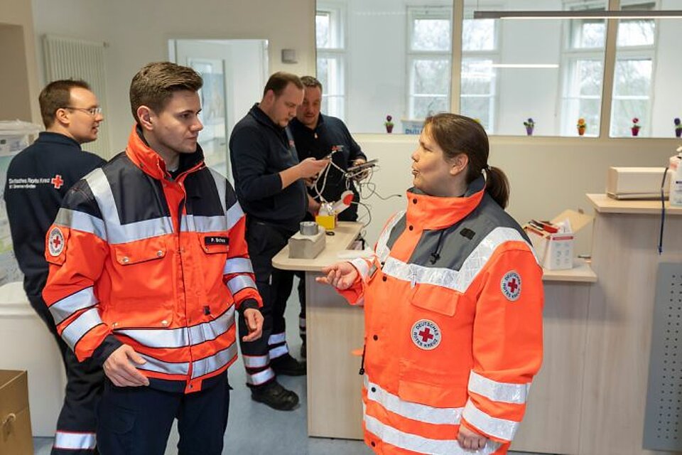 Besprechung zwischen DRK-Mitarbeitern in Quarantäne-Station 