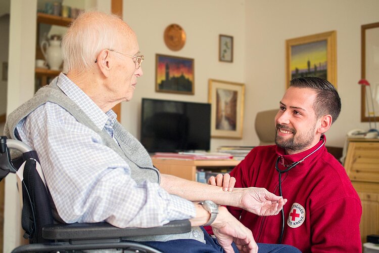 Pfleger misst Blutdruck bei Senior
