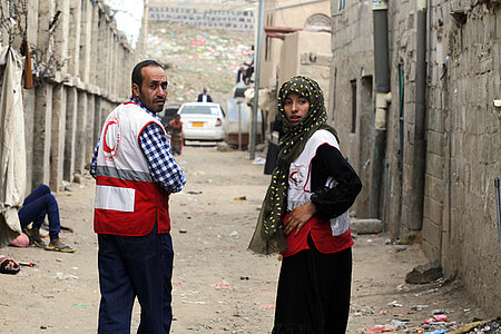 Foto: zwei Rothalbmondshelfer in einer sandigen Straße im Jemen