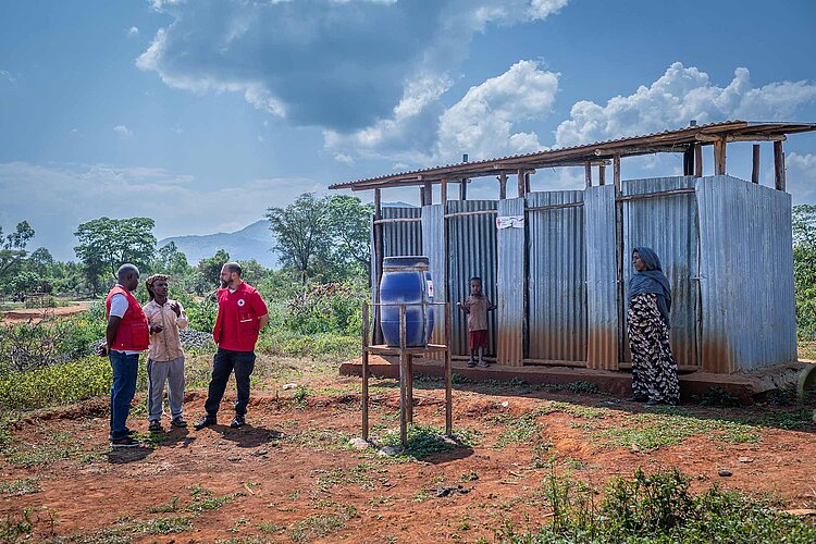 Rotkreuzler vor Latrinen