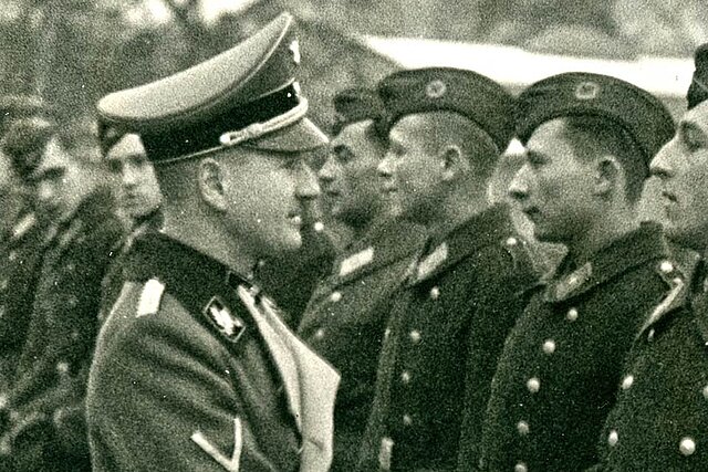 Mann in Uniform reicht Soldaten die Hand