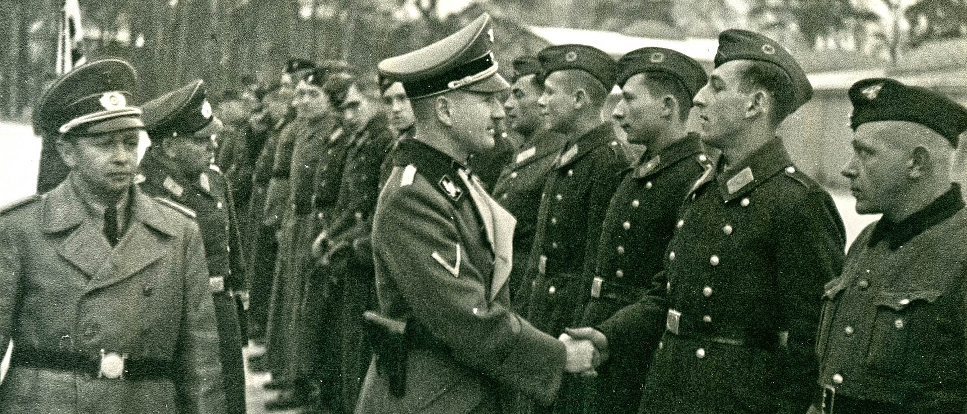 Mann in Uniform reicht Soldaten die Hand