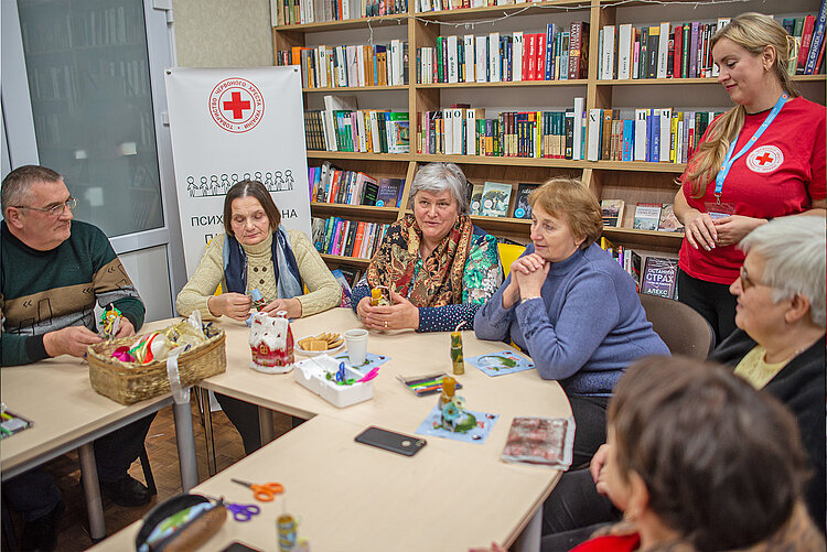 Rotkreuzhelferin und Teilnehmende von Freizeitangeboten in der Ukraine