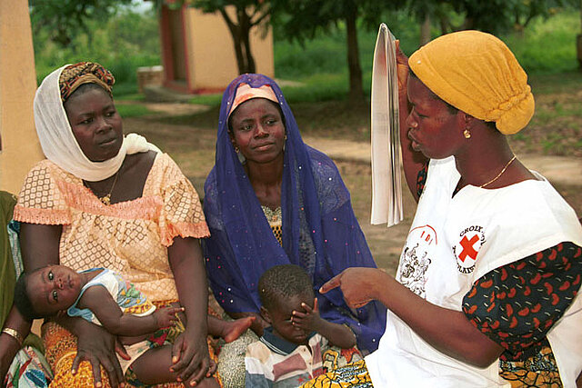Foto: Togolesische Rotkreuzfreiwillige im Gespräch mit 2 Müttern