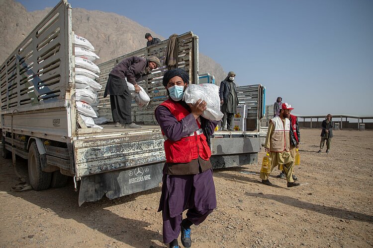 Helfer des Afghanischen Roten Halbmondes mit Hilfsgütern 