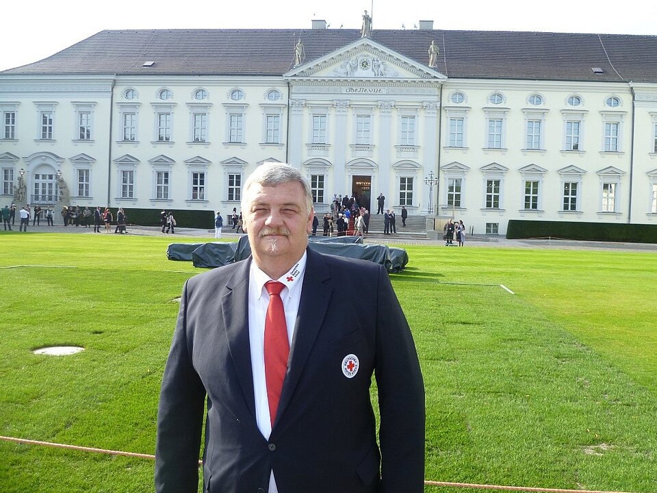DRK-Mitarbeiter Matthias Lippe steht vor dem Schloß Bellevue