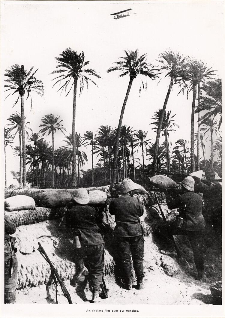 Italienische Soldaten in einem Schützengraben; hoch droben eines der ersten Militärflugzeuge (IKRK) 