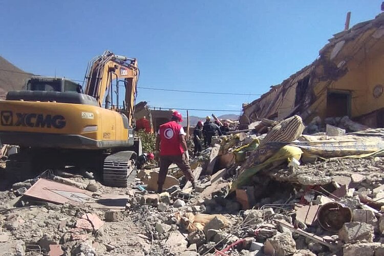 Breitflächige Zerstörungen nach dem Erdbeben in Marokko. Ein Helfer des MRH steht in Trümmern.