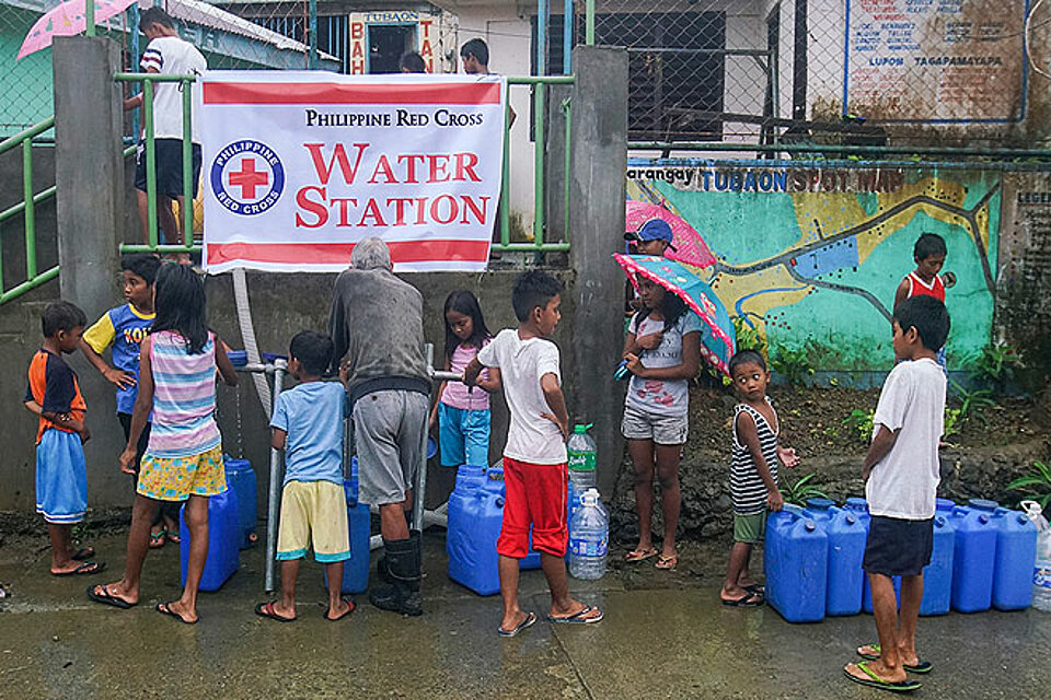 Philippinische Kinder bei der Wasservergabe durch das Philippinische Rote Kreuz nach dem Erdbeben