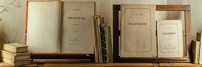 Bücher aus Solferino auf Bücherregal zur DRK Literatur