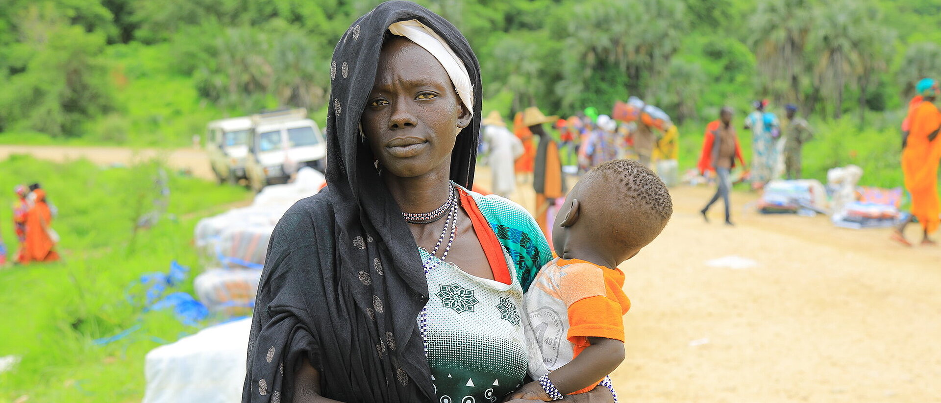 Verteilung von Hilfsgütern an Flüchtlinge aus dem Sudan durch das Äthiopische Rote Kreuz in den Orten Kurmuk und Guba an der Grenze zum Sudan. Frau mit ihrem kleinen Kind auf dem Arm