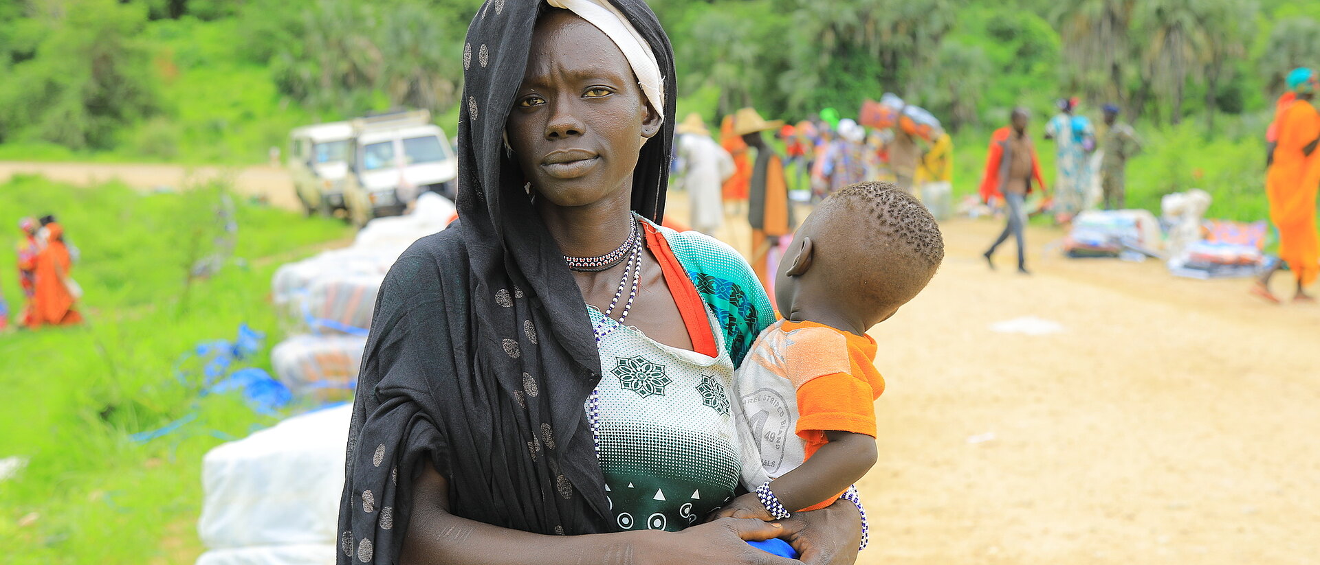 Verteilung von Hilfsgütern an Flüchtlinge aus dem Sudan durch das Äthiopische Rote Kreuz in den Orten Kurmuk und Guba an der Grenze zum Sudan. Frau mit ihrem kleinen Kind auf dem Arm