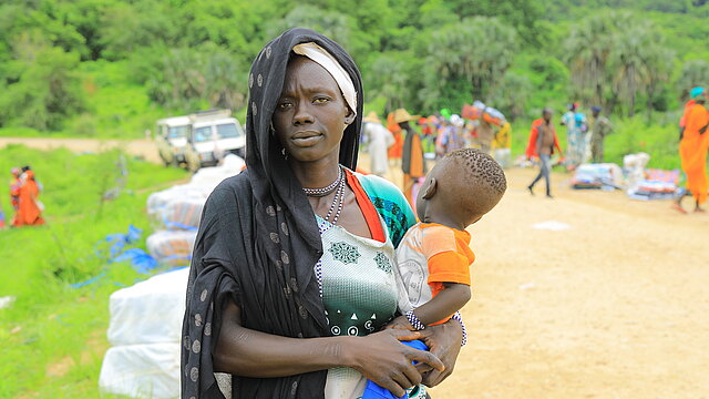 Verteilung von Hilfsgütern an Flüchtlinge aus dem Sudan durch das Äthiopische Rote Kreuz in den Orten Kurmuk und Guba an der Grenze zum Sudan. Frau mit ihrem kleinen Kind auf dem Arm