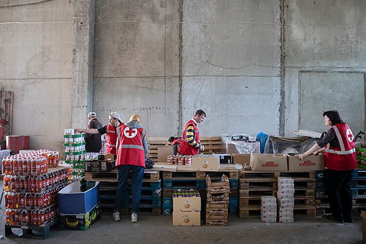 Rotkreuz-Freiwillige packen Lebensmittelpakete in einem Lebensmittellager