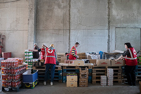 Rotkreuz-Freiwillige packen Lebensmittelpakete in einem Lebensmittellager