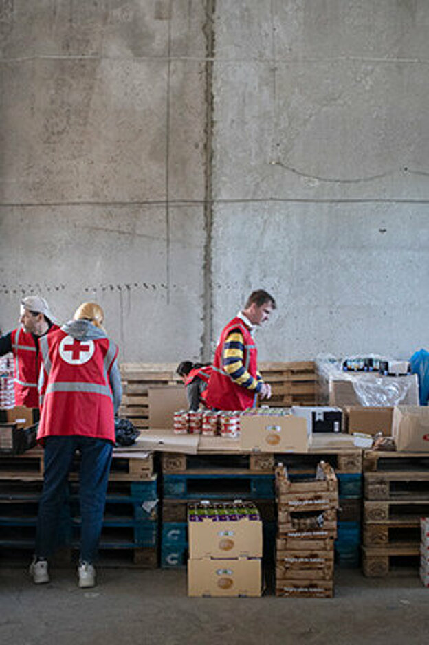 Rotkreuz-Freiwillige packen Lebensmittelpakete in einem Lebensmittellager