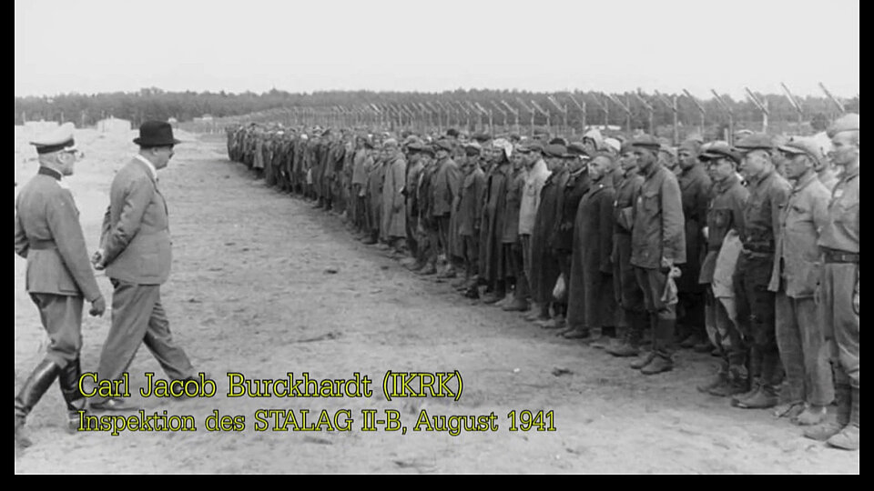 Zwei Männer gegenüber einer Gruppe von Gefangenen