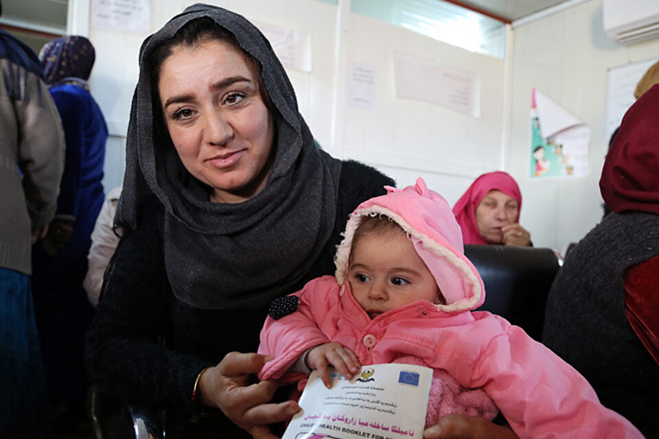 Foto: Junge syrische Mutter mit ihrem Baby im Arm