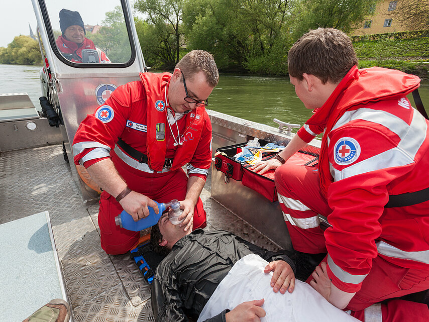 Deutsches Rotes Kreuz DRK, Einsatzbereiche / Aktivitaeten / Leistungen / Aufgaben, Erste Hilfe Rettung und Bevoelkerungsschutz, Wasserwacht, Boot, Übung, Wasserrettung, Fluss, Rettungseinsatz, Spineboard, Beatmung, Sauerstoff, Querformat QF