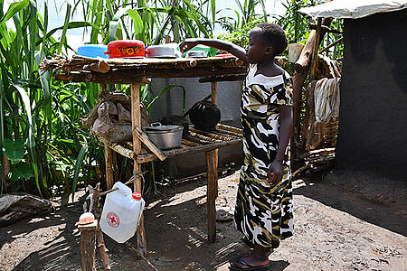 geflüchtetes Mädchen in Uganda an einer provisorischen Außenküche