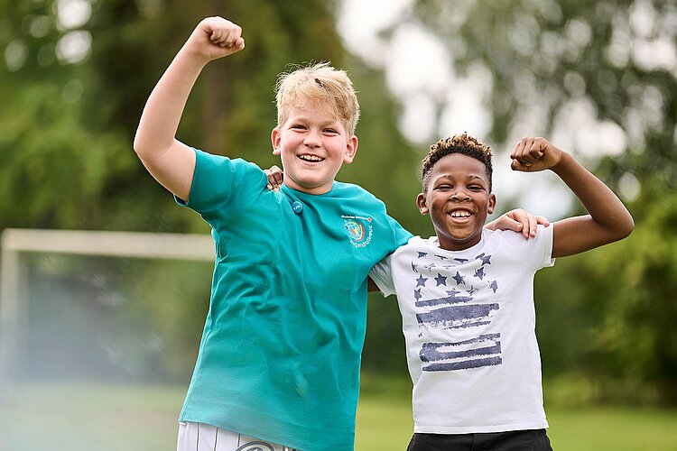 JRK macht Freunde Zwei lachende Jungen machen Siegerfaust